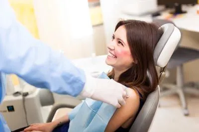 woman smiling during her visit at Hymas Family Dental