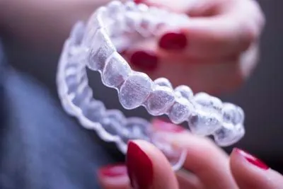 patient holding their new Invisalign clear aligners