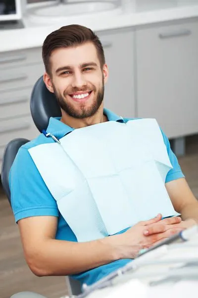 patient smiling after his oral surgery procedure helped restore his smile